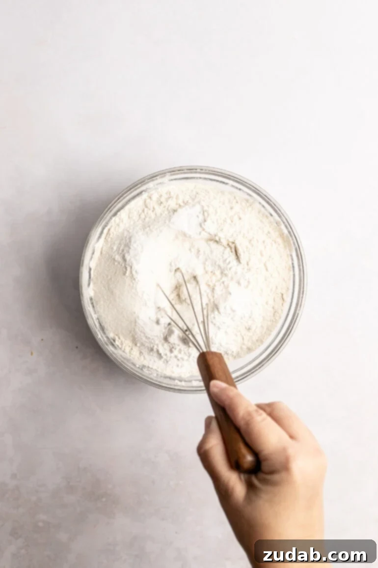 Step-by-step image of whisking dry ingredients in a bowl.