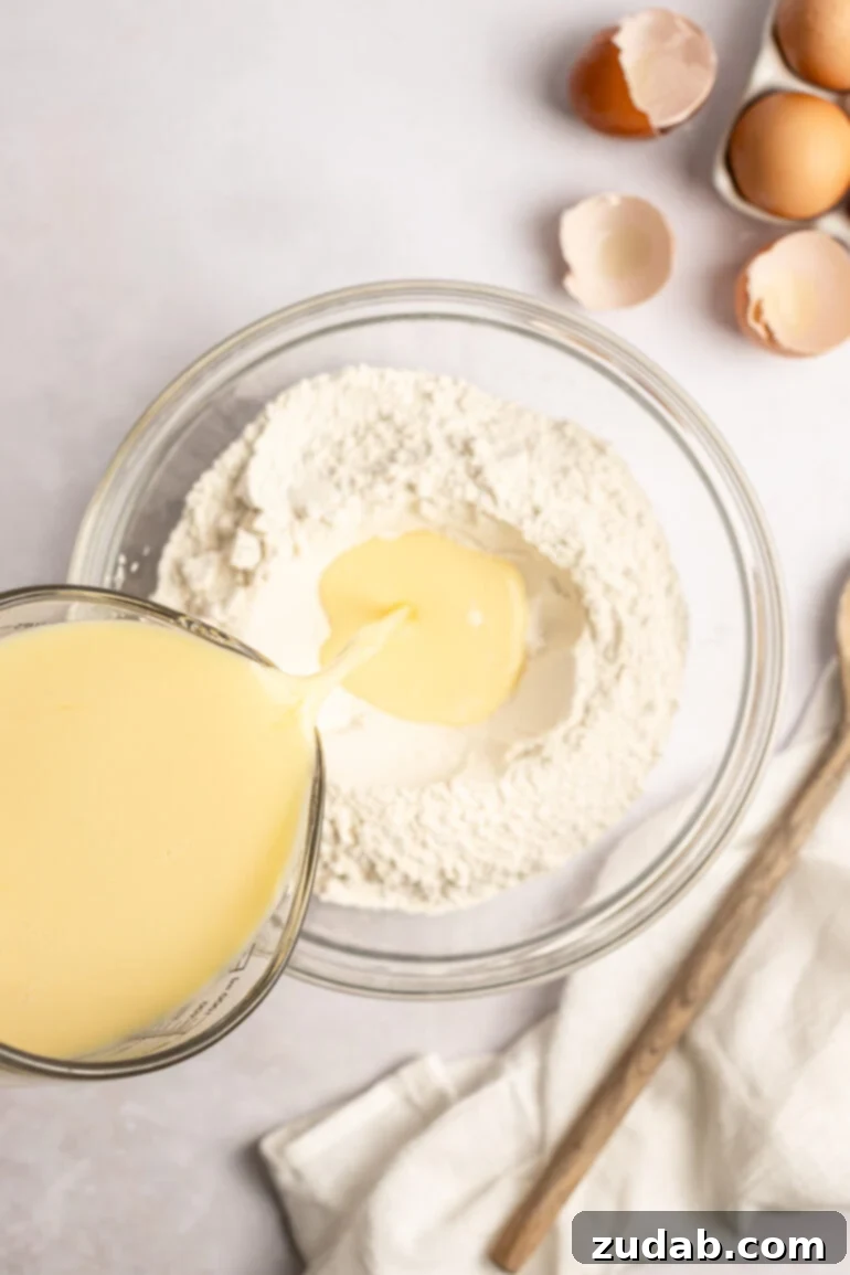 Step-by-step image of pouring wet ingredients into dry ingredients.