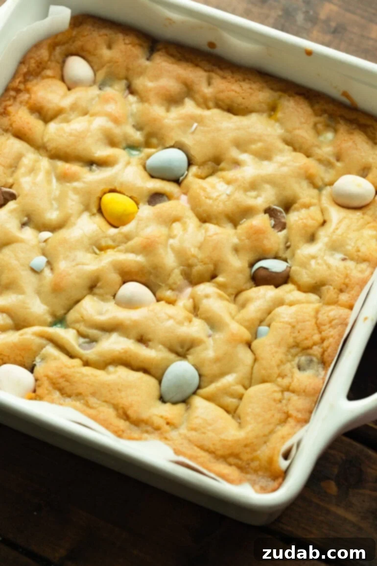 Ultimate Easter Cadbury Mini Egg Blondies 2 Pan of freshly baked blondies with melted Cadbury Mini Eggs peeking through the top.