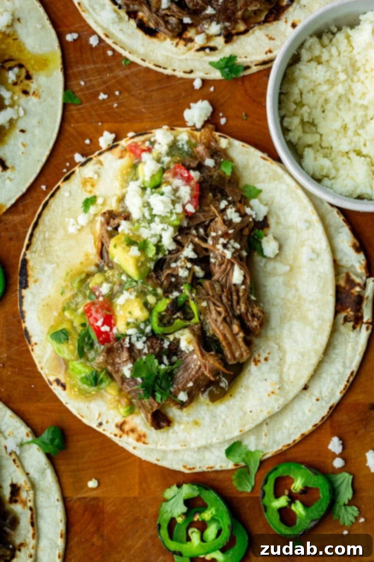 Fall-Apart Poblano Beef Tacos from One Pot 3 Overhead view of shredded beef tacos filled with flavorful meat, bright salsa, and melted queso fresco.