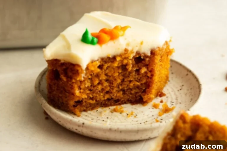 Effortless Carrot Cake: The Baby Food Secret 11 a piece of moist carrot cake with a bite taken out of one corner, topped with cream cheese frosting