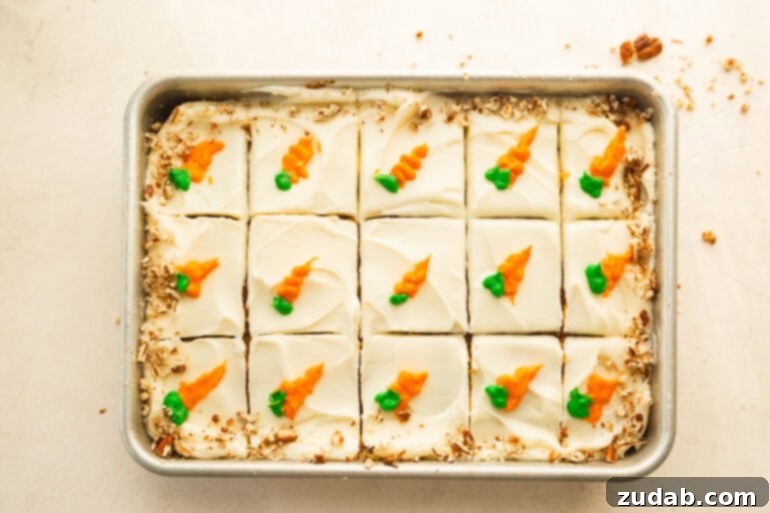 Effortless Carrot Cake: The Baby Food Secret 5 a baked and frosted carrot cake sliced into pieces with a little carrot piped on each piece