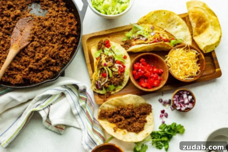 Speedy Weeknight Beef Tacos 5 all the toppings for ground beef tacos in separate small bowls around corn tortillas filled with ground beef