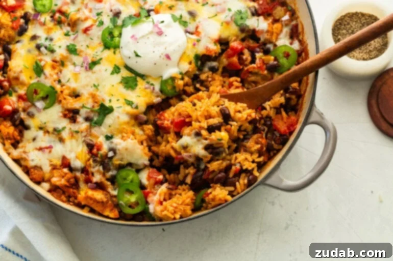 Overhead view of baked chicken taco casserole in an enameled baking dish.