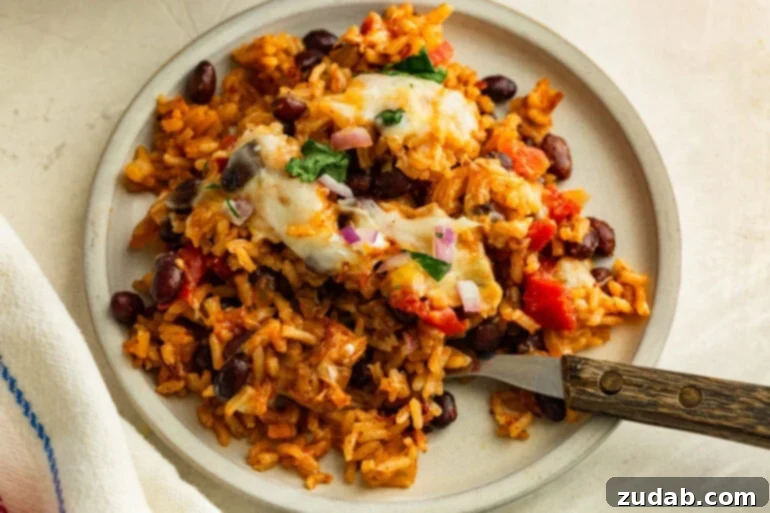 Overhead image of a plate of baked chicken taco casserole on a plate with a fork.
