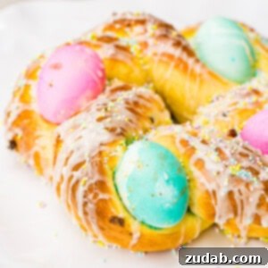 Beautifully braided Easy Italian Easter Bread, decorated with colorful sprinkles and whole eggs.