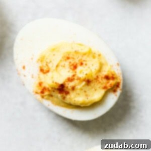 A platter of classic deviled eggs, garnished and ready for serving, an Easter dinner staple.