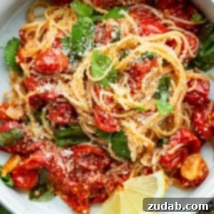 A bowl of Tomato and Basil Pasta garnished with fresh basil leaves.
