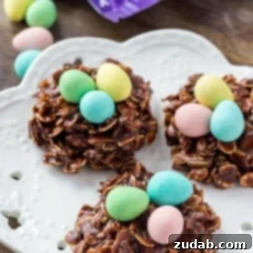 Three Easter Nest Cookies on a white plate topped with miniature eggs.