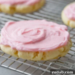 A photo of a copycat Swig sugar cookie with pink frosting sitting on a cooling rack.