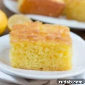 Slice of Lemon Jello Cake on a white plate.