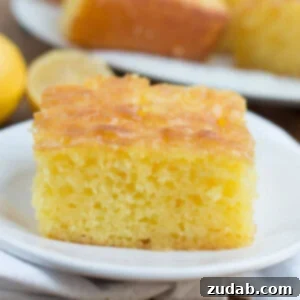 Slice of Lemon Jello Cake on a white plate.