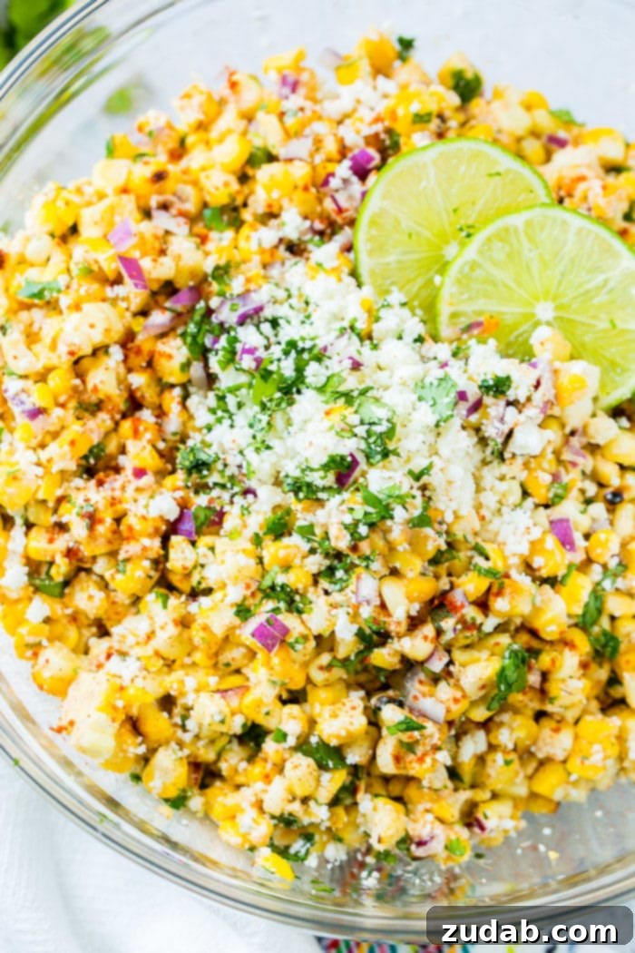 Easy Authentic Cinco de Mayo Recipes for Your Fiesta 54 A glass bowl full of grilled corn, red onions, cilantro, crema, cotija cheese and lime juice which makes the best elote mexican grilled corn salad