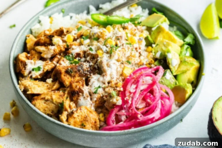 Creamy Esquites Chicken Rice Bowls 6 A vibrant chicken rice power bowl with creamy Mexican street corn, sliced avocado, pickled red onions, and fresh jalapeños, showcasing a healthy and flavorful meal.