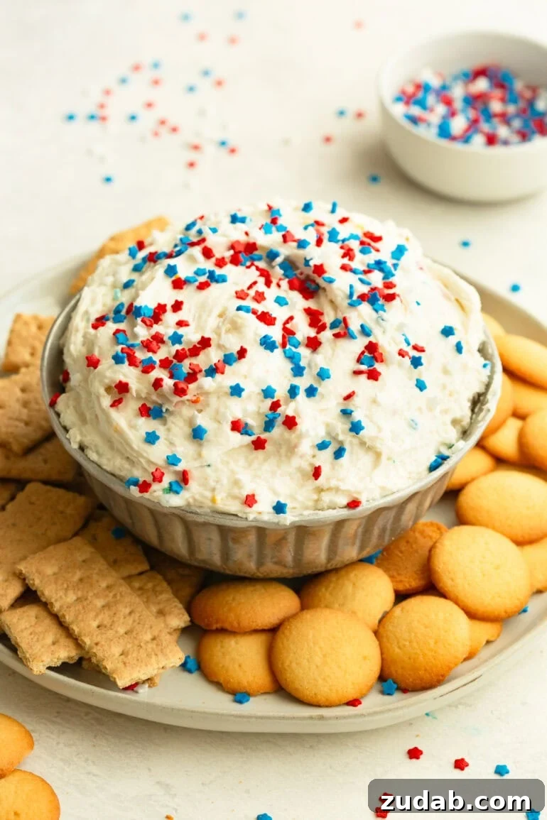 Red White and Blue Funfetti Dip Recipe for Patriotic Parties 2 Funfetti Dip topped with colorful red white and blue sprinkles next to graham crackers and Nilla wafers.