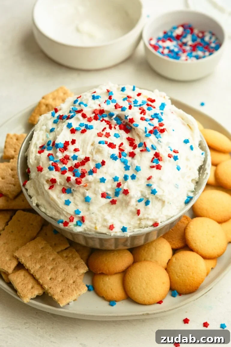 Red White and Blue Funfetti Dip Recipe for Patriotic Parties 3 Overhead view of Funfetti Dip in a bowl with sprinkles and dippers around it.