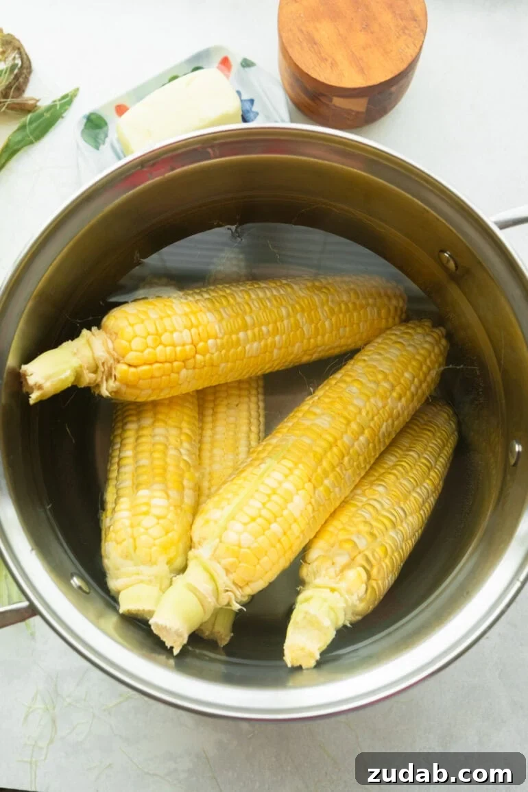 How to Cook Corn on the Cob Perfectly Every Time 3 five ears of corn sitting in a large stock pot full of water