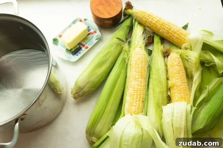 How to Cook Corn on the Cob Perfectly Every Time 4 all the ingredients for the best corn on the cob including corn still in its husk, butter, salt and pepper and a large pot of water