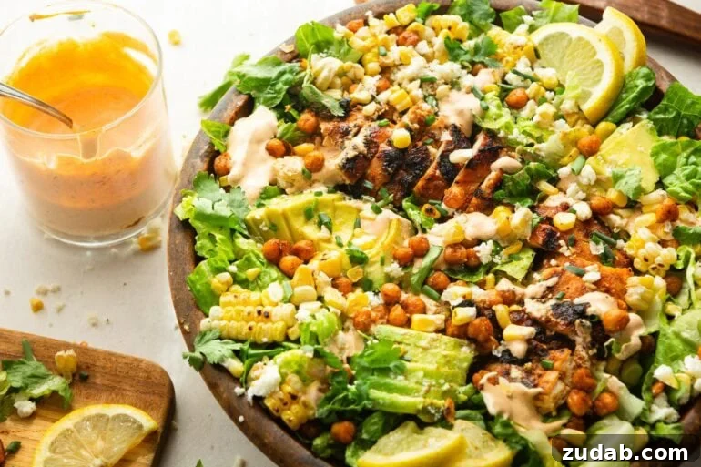 Southwest Ranch Grilled Chicken Salad Recipe 4 a large wooden bowl grilled chicken salad topped with sliced avocado, crispy chickpeas and drizzled with southwest ranch