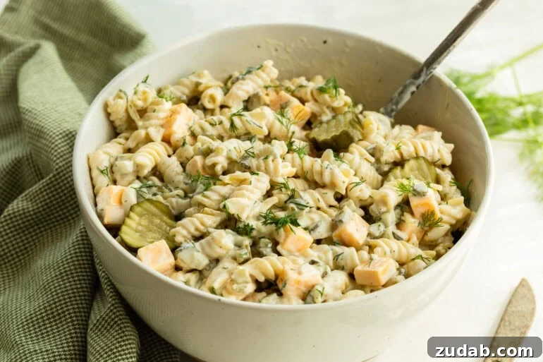 Creamy Dill Pickle Pasta Salad with Crunchy Cucumbers 2 A large bowl of dill pickle pasta salad with noodles in a creamy sauce, pickles, and cheddar cheese
