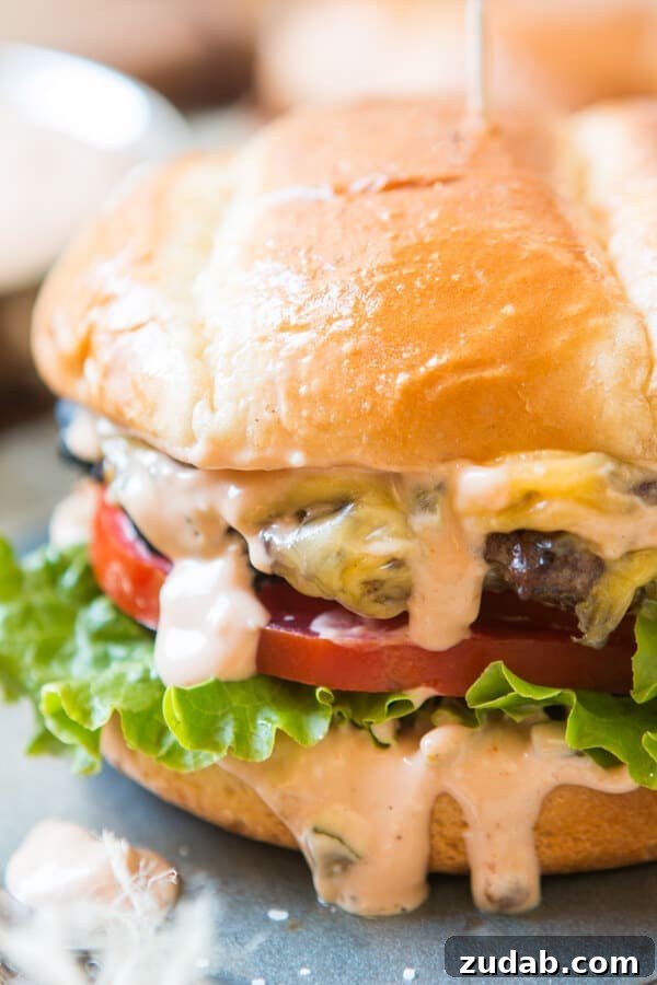 Classic Burger Sauce Recipe for Juicy Homemade Burgers 2 the best burger sauce dripping out the sides of a cheeseburger with golden bun, lettuce and tomatoes