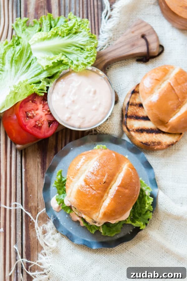 Classic Burger Sauce Recipe for Juicy Homemade Burgers 5 the best hamburger being assembled with a grilled buttery bun, burger sauce, lettuce and tomatoes